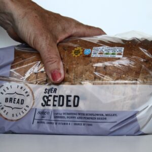 loaf of seeded bread with hand