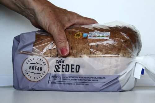 loaf of seeded bread with hand